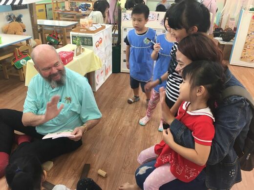 Robin on floor with Taiwanese children