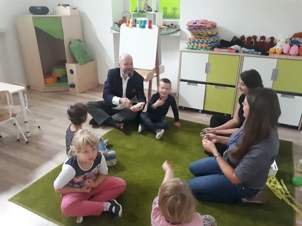 Robin on floor with Polish children & teacers